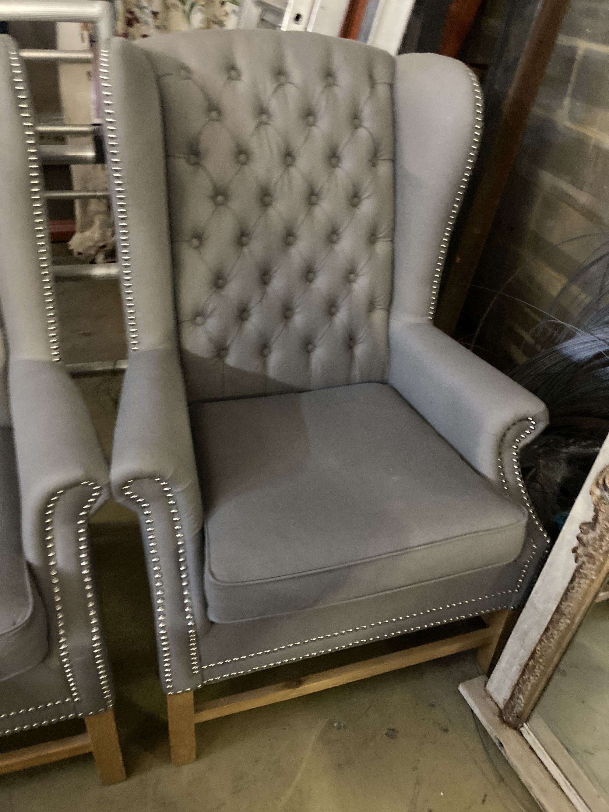 A pair of Victorian style wing armchairs, recently re-upholstered in buttoned grey fabric, width 82cm depth 78cm height 116cm